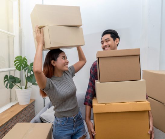Asian Young Couple Carrying Big Cardboard Box For 32b4jqa.jpg